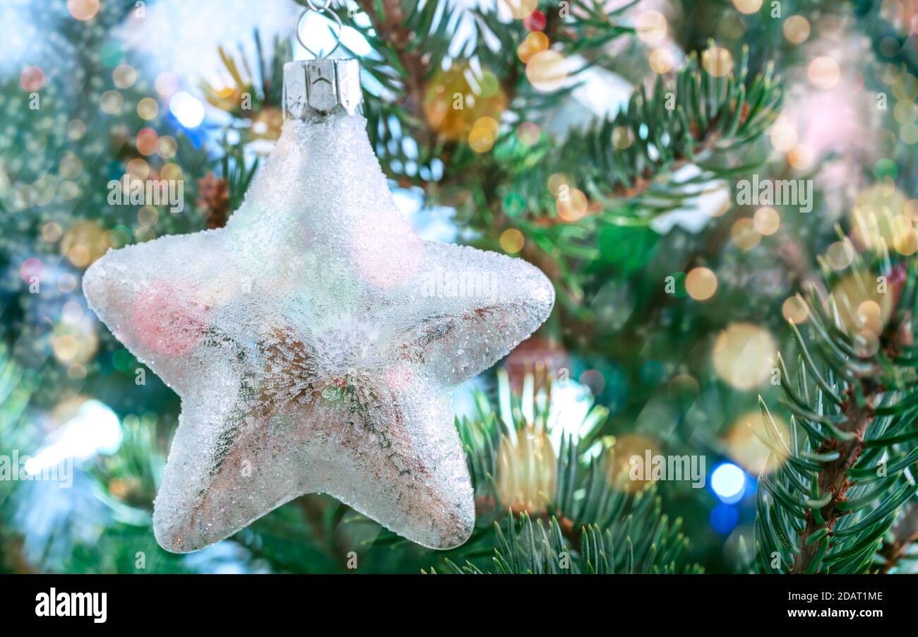 Glitzernder Glasstern - weihnachtsdekoration auf Tannenzweigen Stockfoto