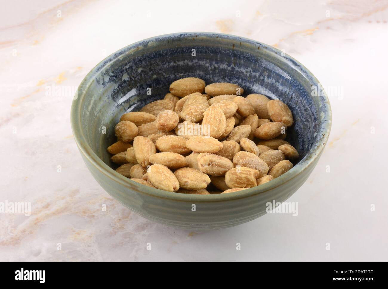 Ganze Mandeln gewürzt mit Himalaya-rosa Salz in Keramik-Snack Schüssel auf dem Tisch Stockfoto