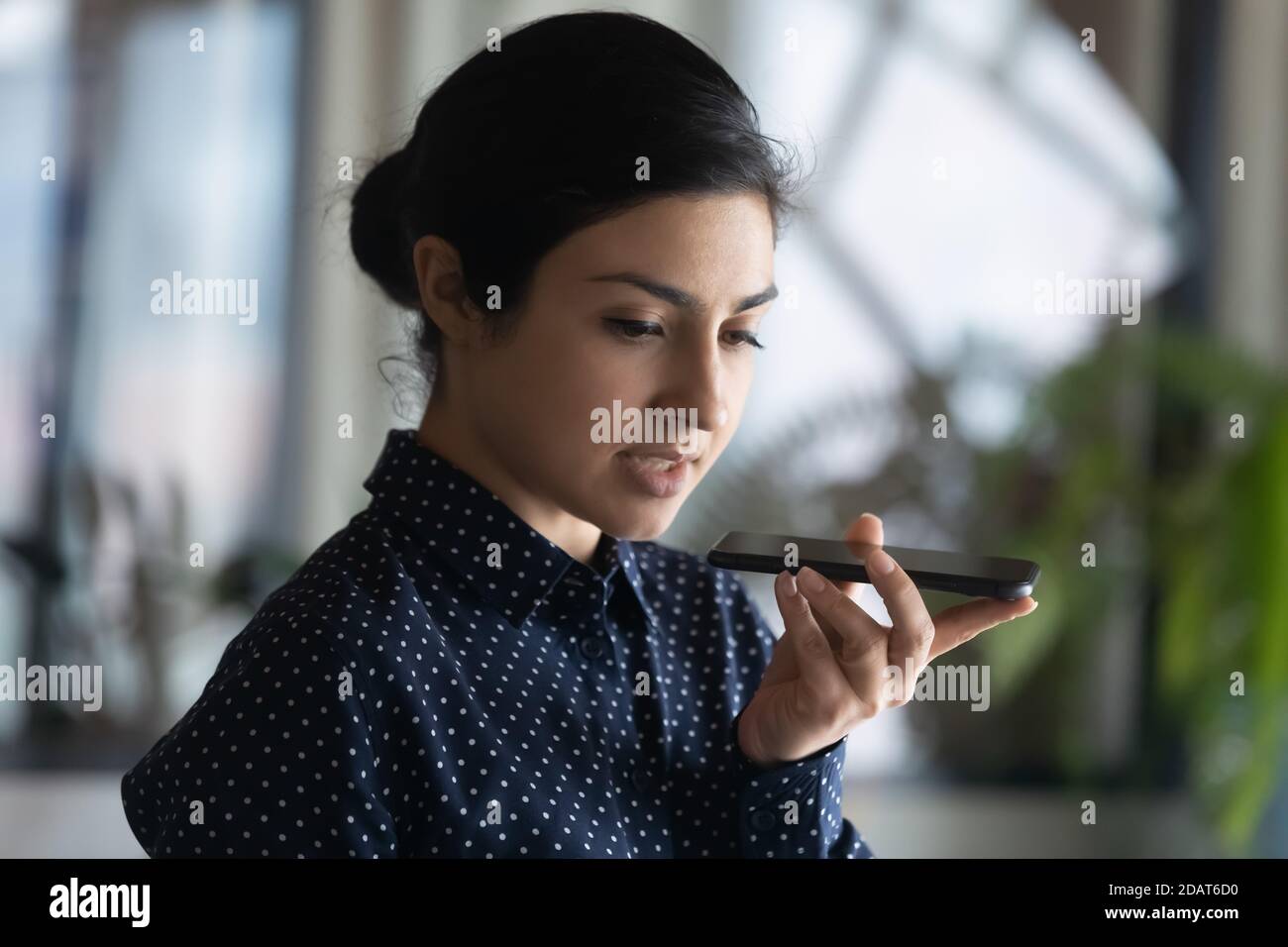 Nahaufnahme ernsthafte indische Geschäftsfrau Aufnahme Sprachnachricht am Telefon Stockfoto