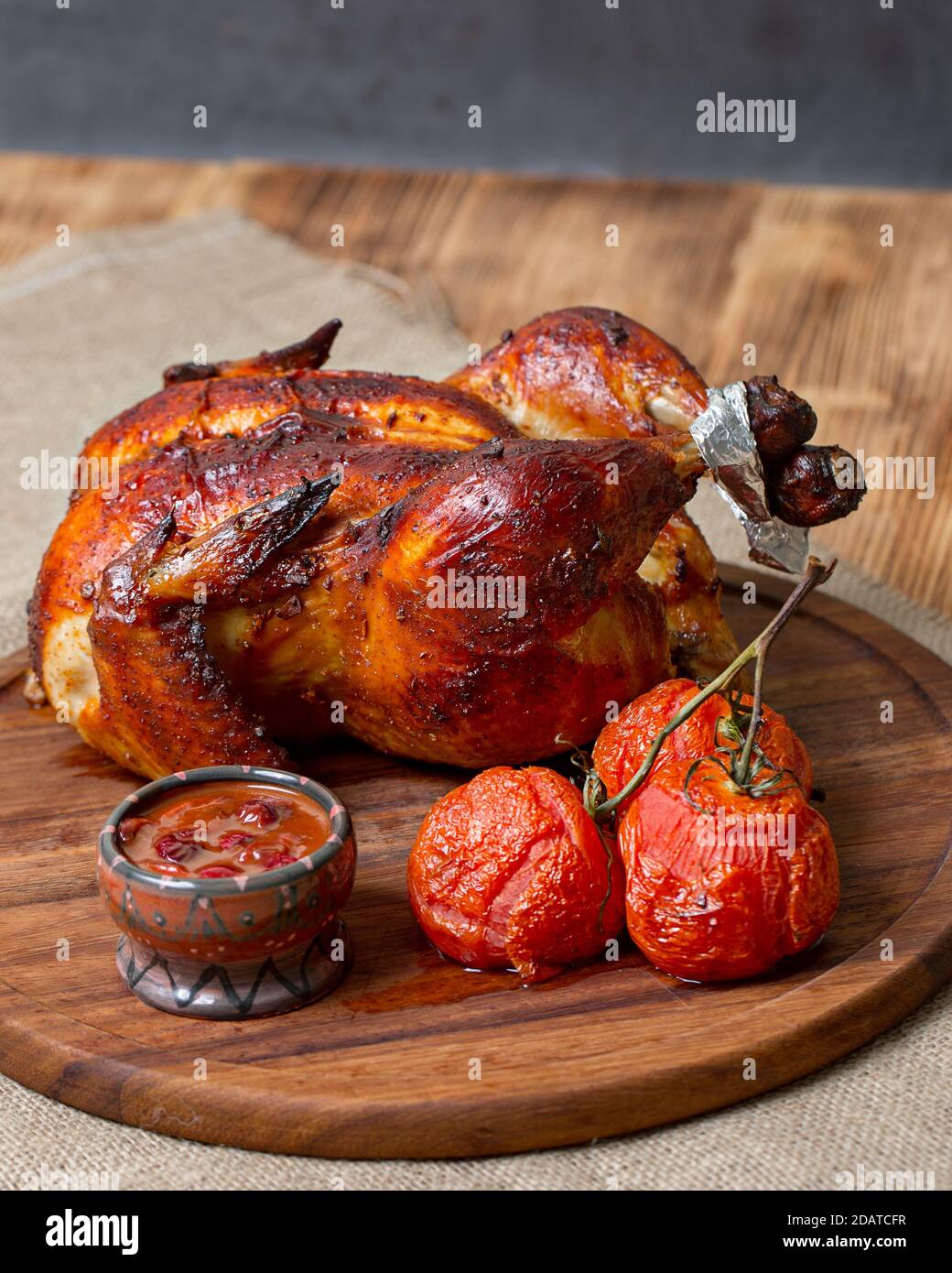 Hähnchen im Ofen gebacken, mit Sauce, auf einem hölzernen Hintergrund Stockfoto