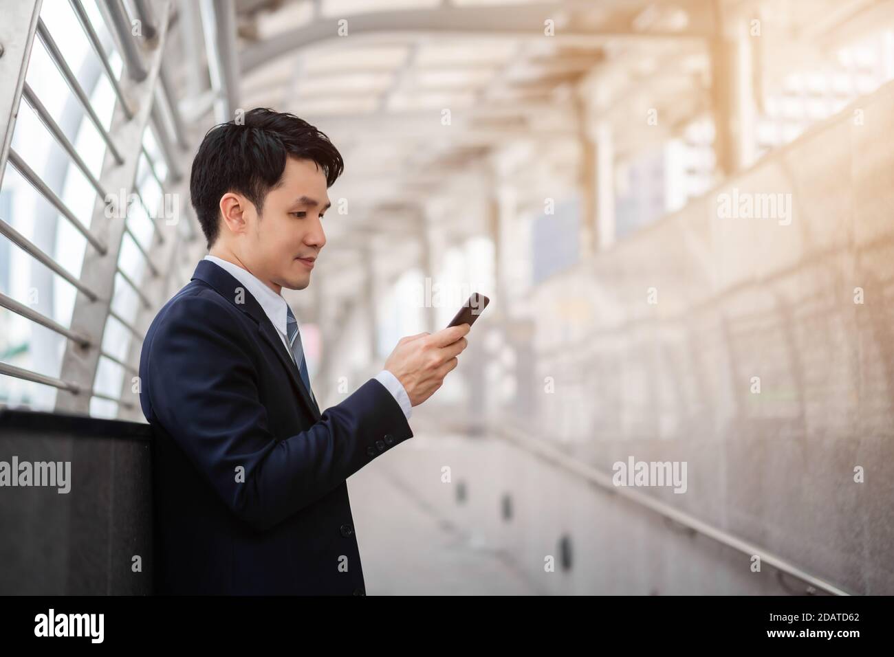 Geschäftsmann im Anzug mit Smartphone in der Stadt Stockfoto