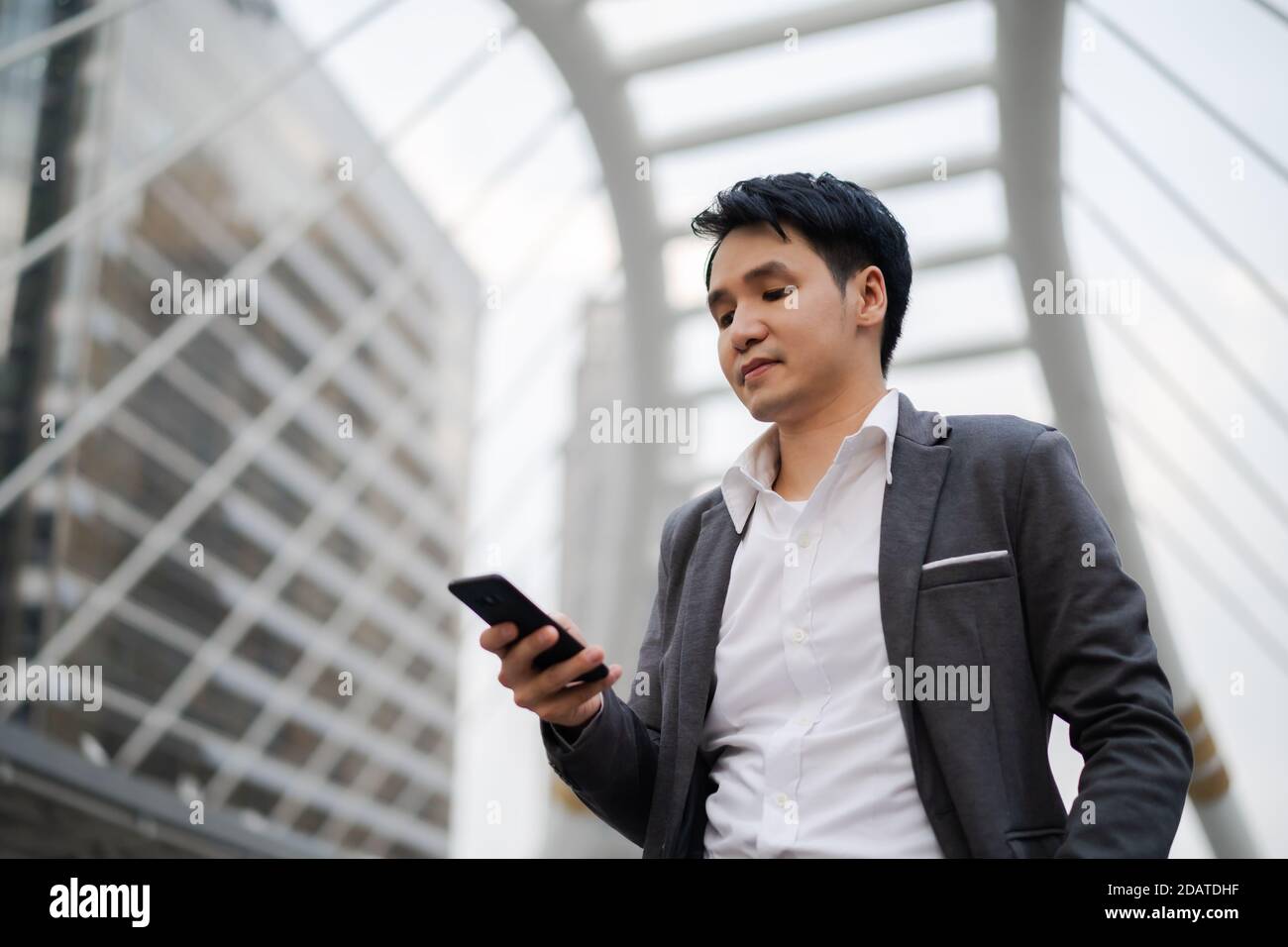 Geschäftsmann im Anzug mit Smartphone in der Stadt Stockfoto