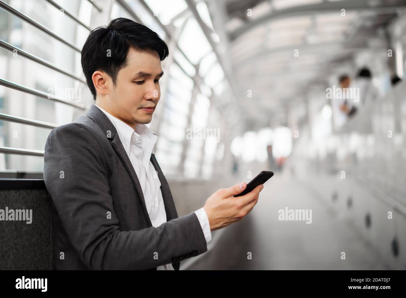 Geschäftsmann im Anzug mit Smartphone in der Stadt Stockfoto