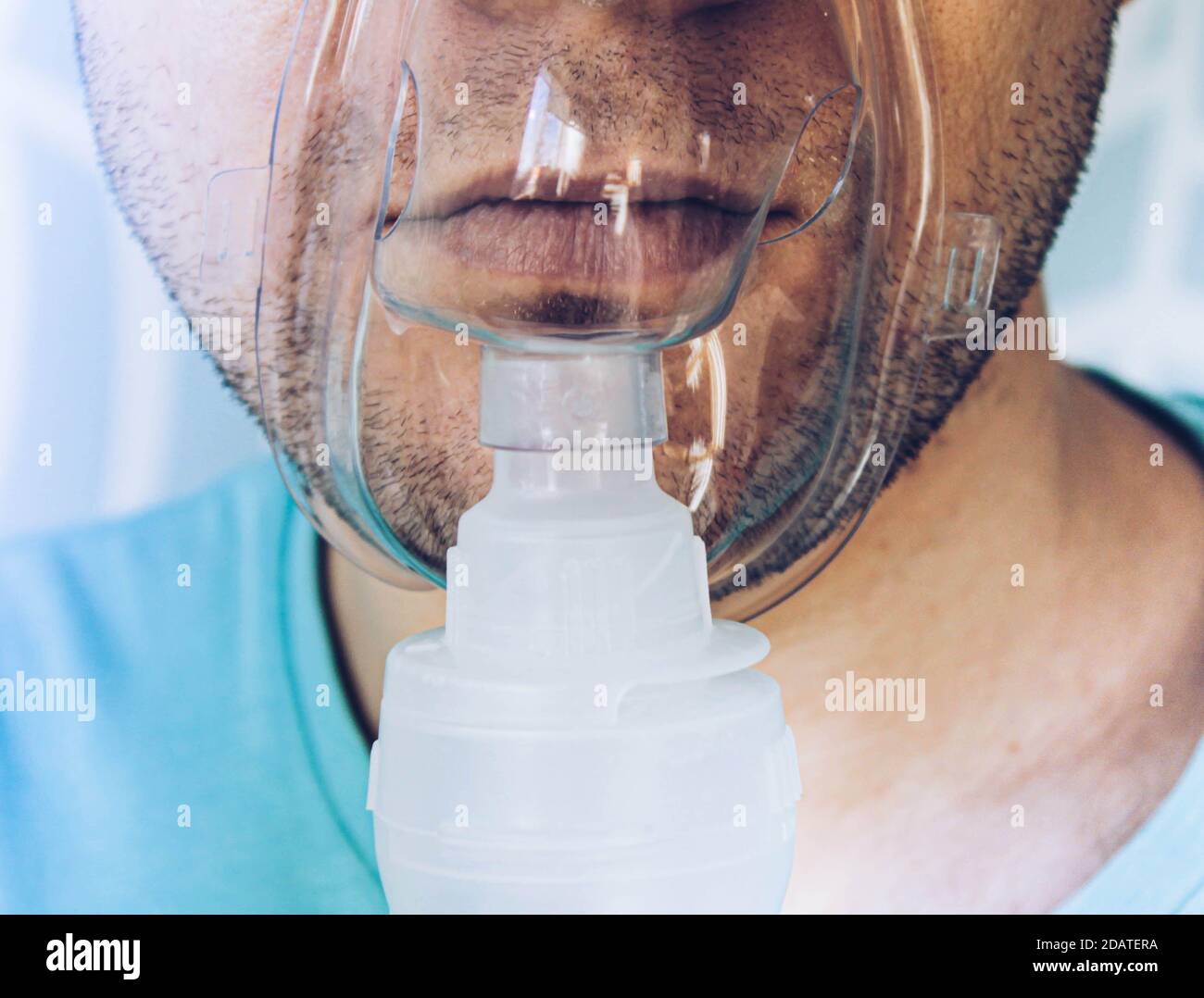 Ein Mann mit einer Inhalationsmaske im Gesicht. Stockfoto