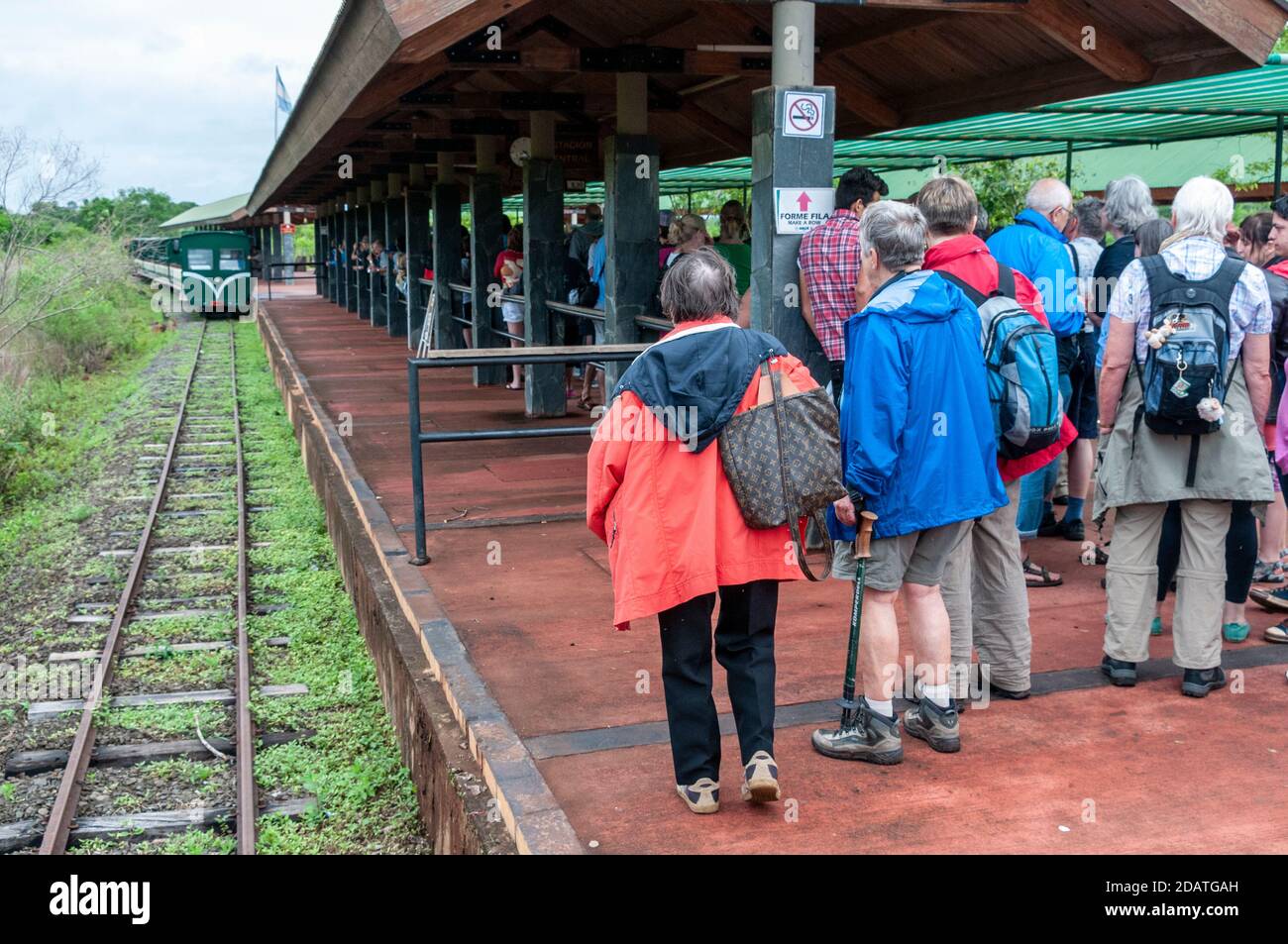 Besucher warten auf dem Bahnsteig als der Dschungel Zug (Regenwald Ökologischen Zug) nähert sich Hauptbahnhof im Iguazu Nationalpark, Argentinien. T Stockfoto