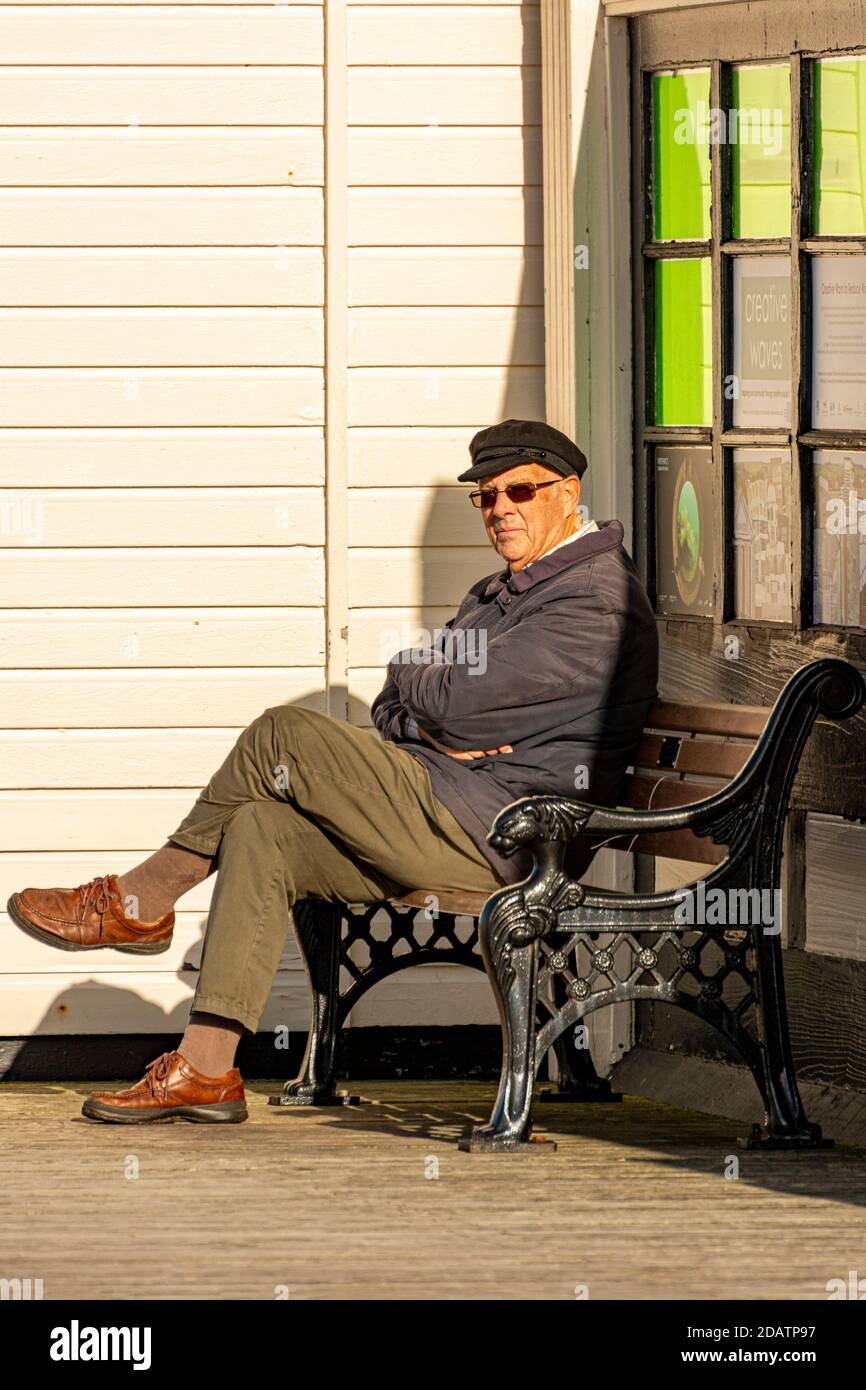 Ein älterer Herr, der alleine sitzt. Stockfoto