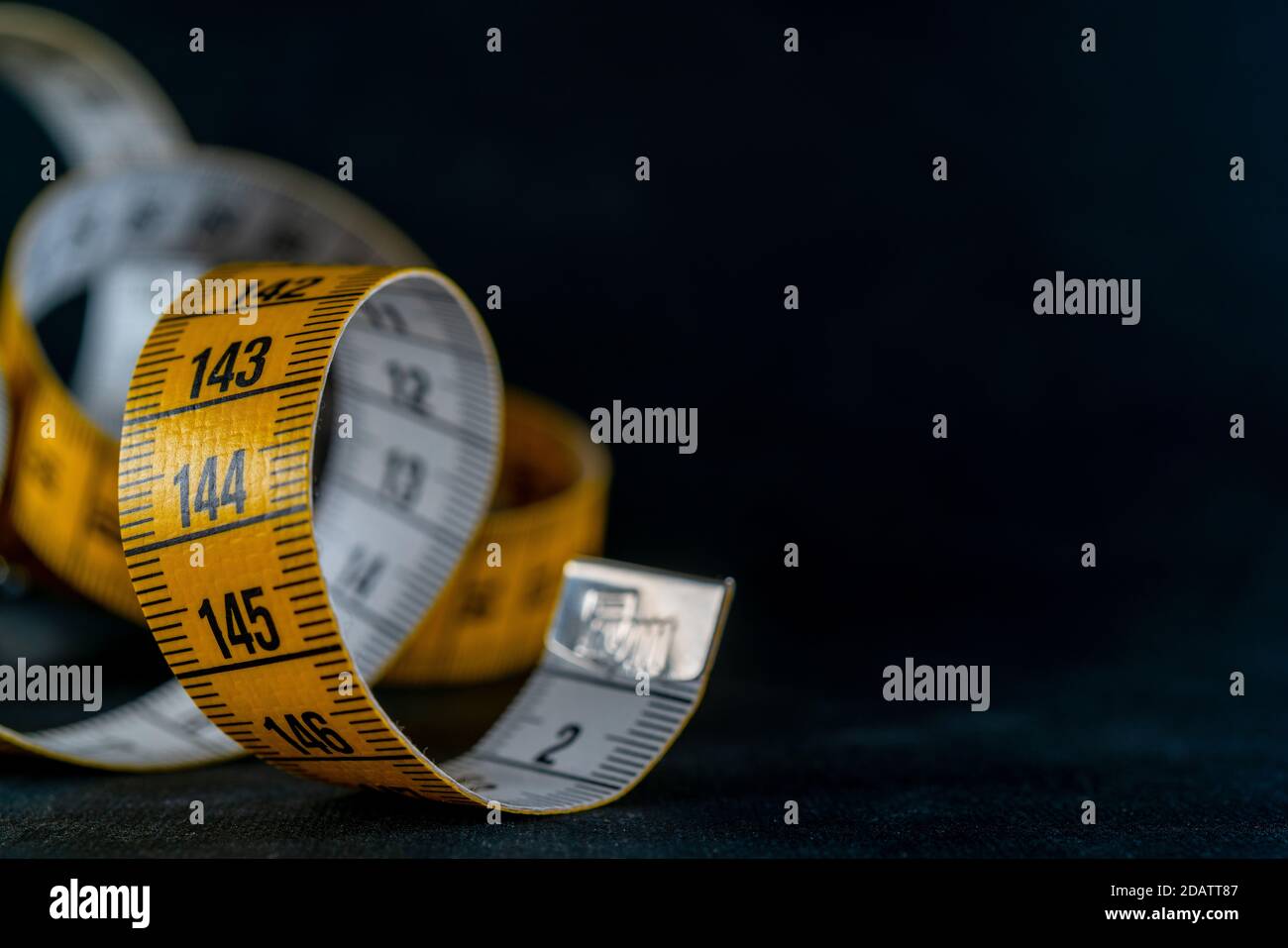 Gelbes Maßband auf dunklem Hintergrund. Stockfoto