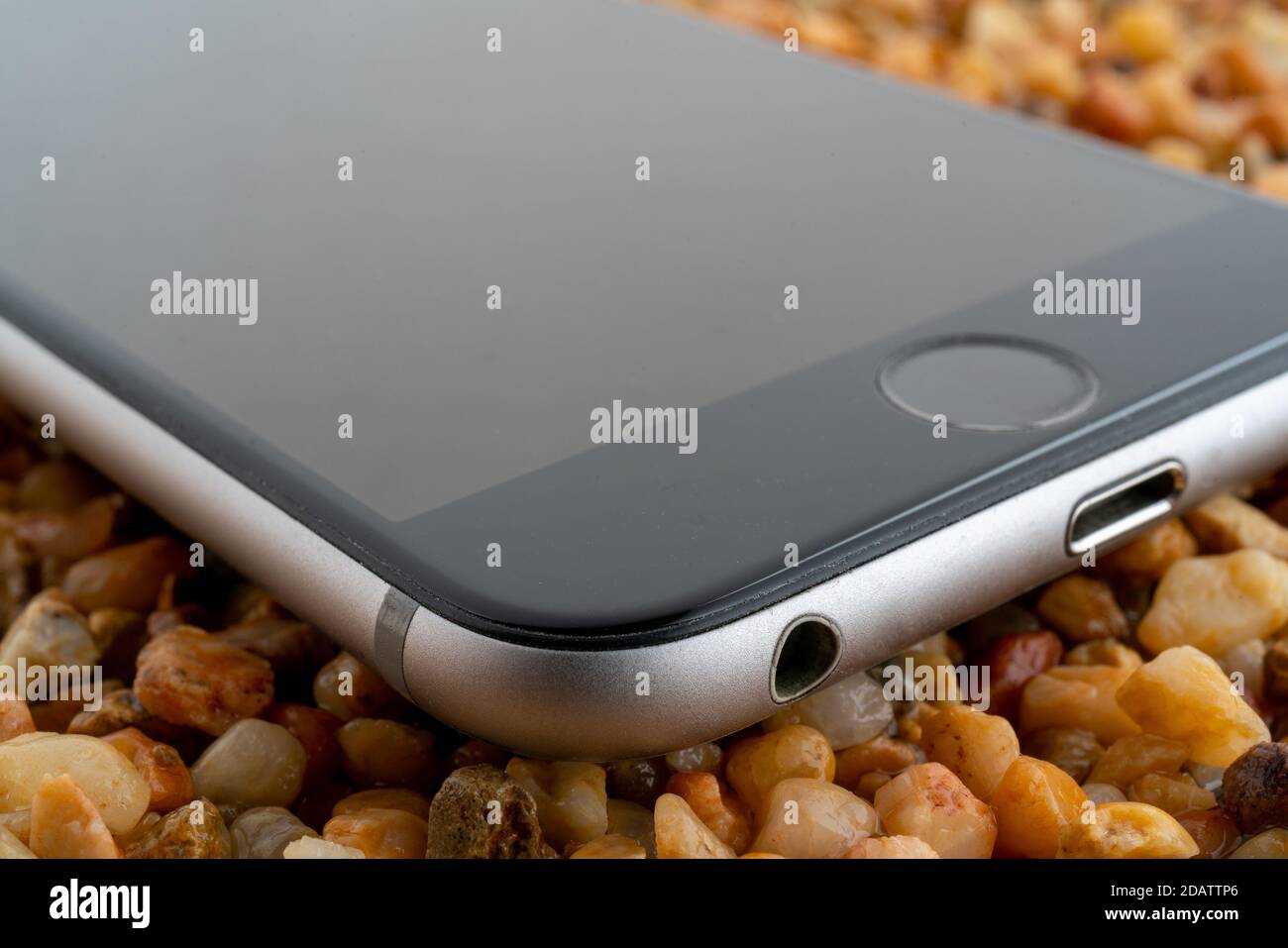 Das Smartphone liegt auf dem gelben Sand. Moderne Technologien. Stockfoto