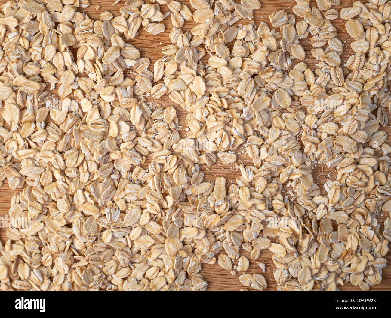 Draufsicht Aufnahme von Getreideflocken auf der Holzoberfläche, nahtlose Textur Stockfoto