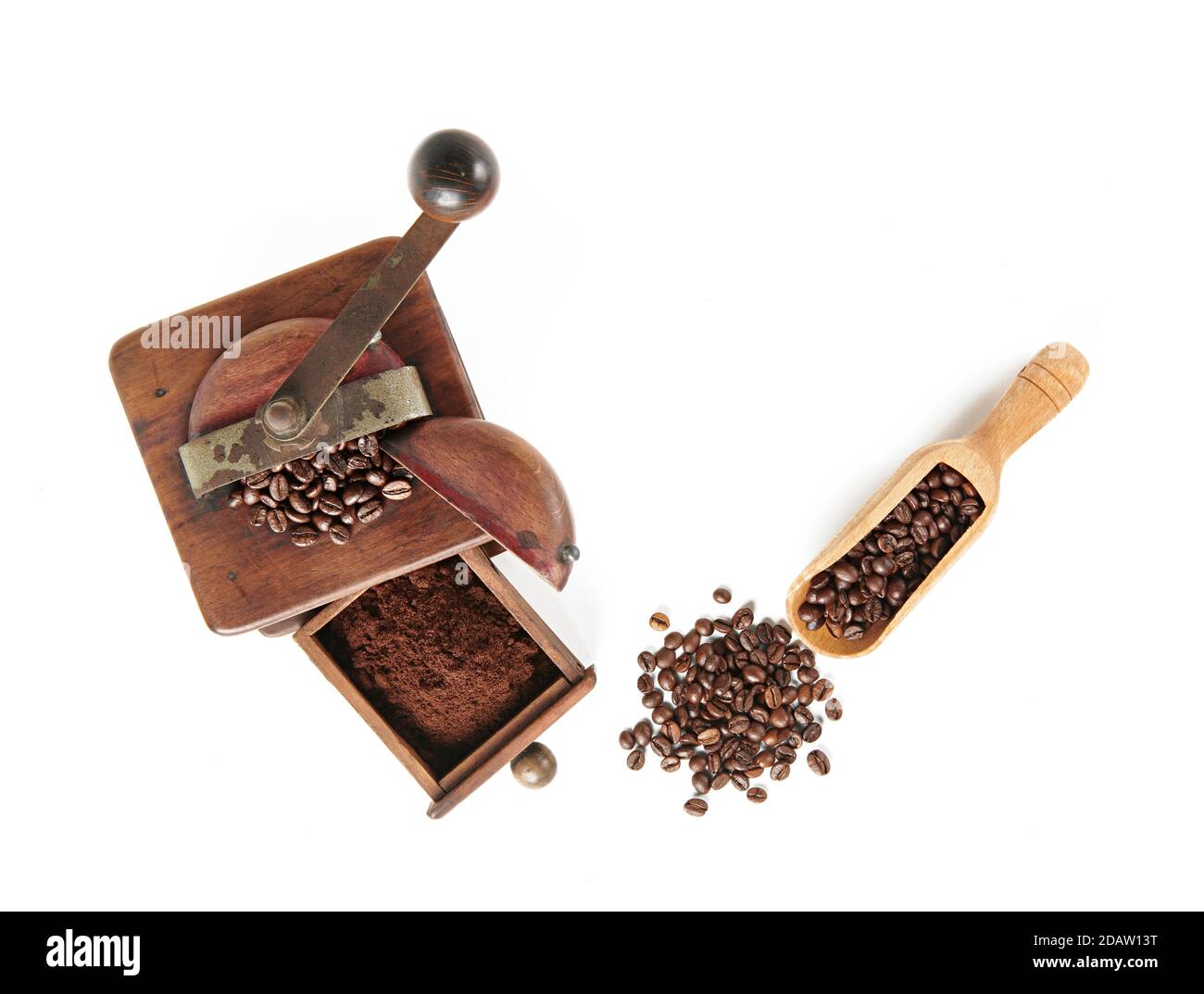 Kaffeebohnen mit Kaffeemühle aus Holz und Holzlöffel, von oben auf weißem Hintergrund, mit Schatten. Stockfoto