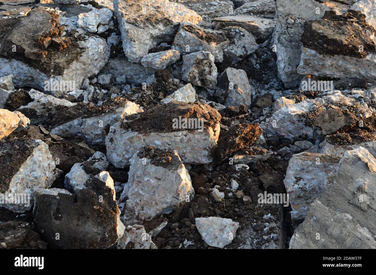 Zerbrochene Asphaltstücke auf einer Baustelle. Recycling und Wiederverwendung zerkleinerten Betonschutt, Asphalt, Baumaterial, Blöcke. Zerkleinert сoncrete Bac Stockfoto