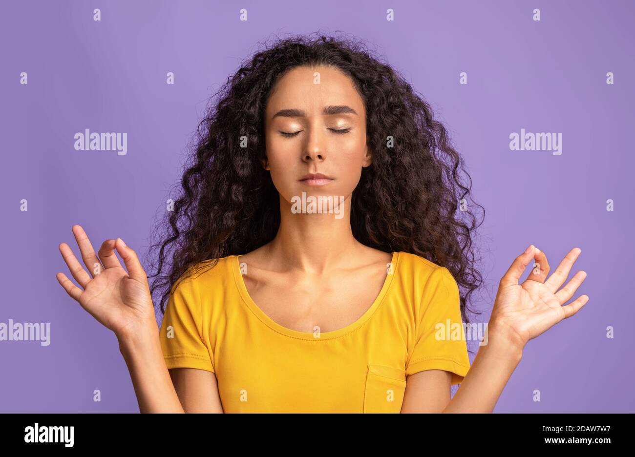 Zen. Ruhige Dame meditiert über lila Hintergrund, die Hände in Mudra-Geste halten Stockfoto
