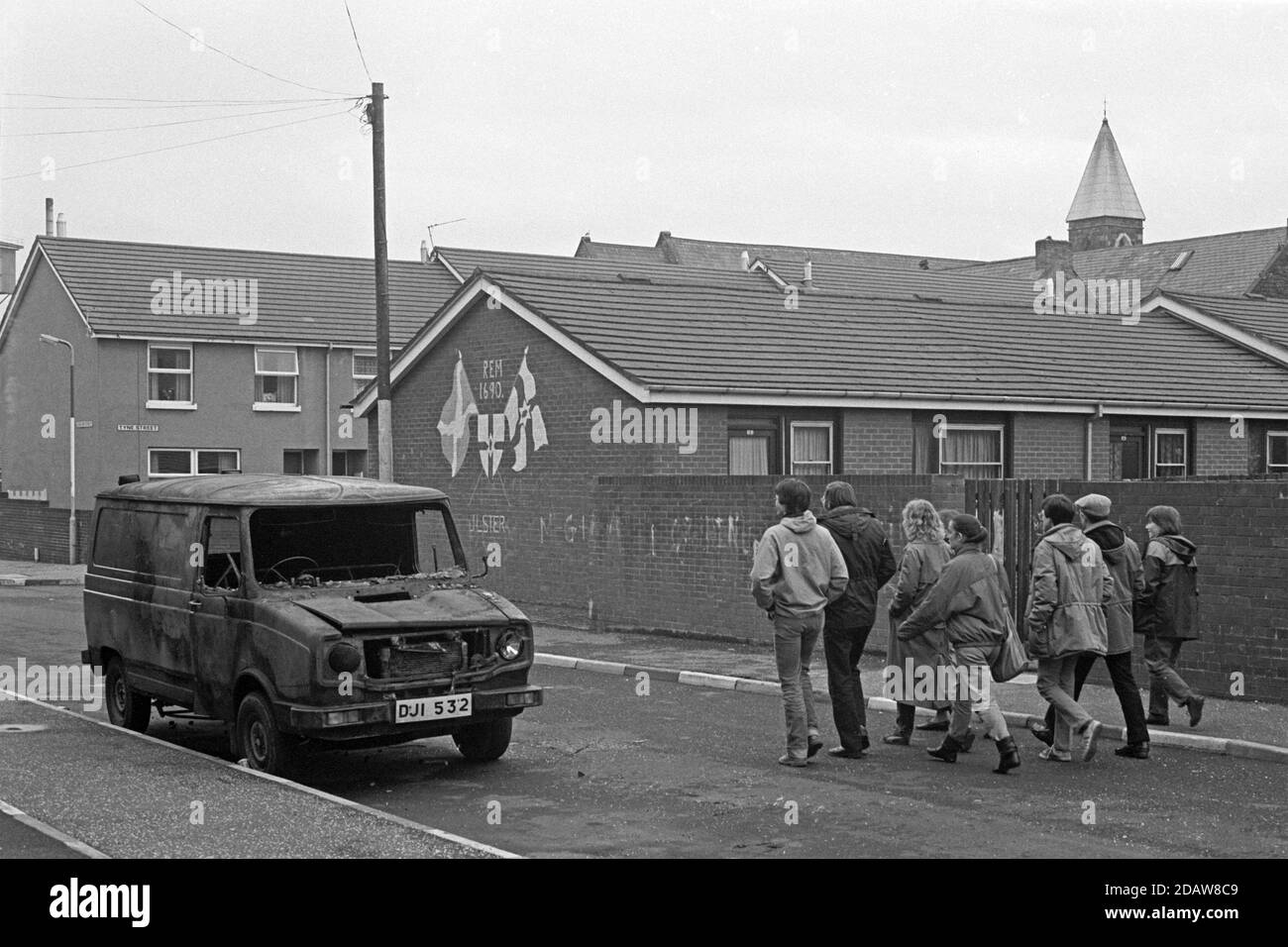 Ausgebrannter Van und Wandgemälde, Shankill Road Area, Carlow Street, April 1986, Belfast, Nordirland Stockfoto