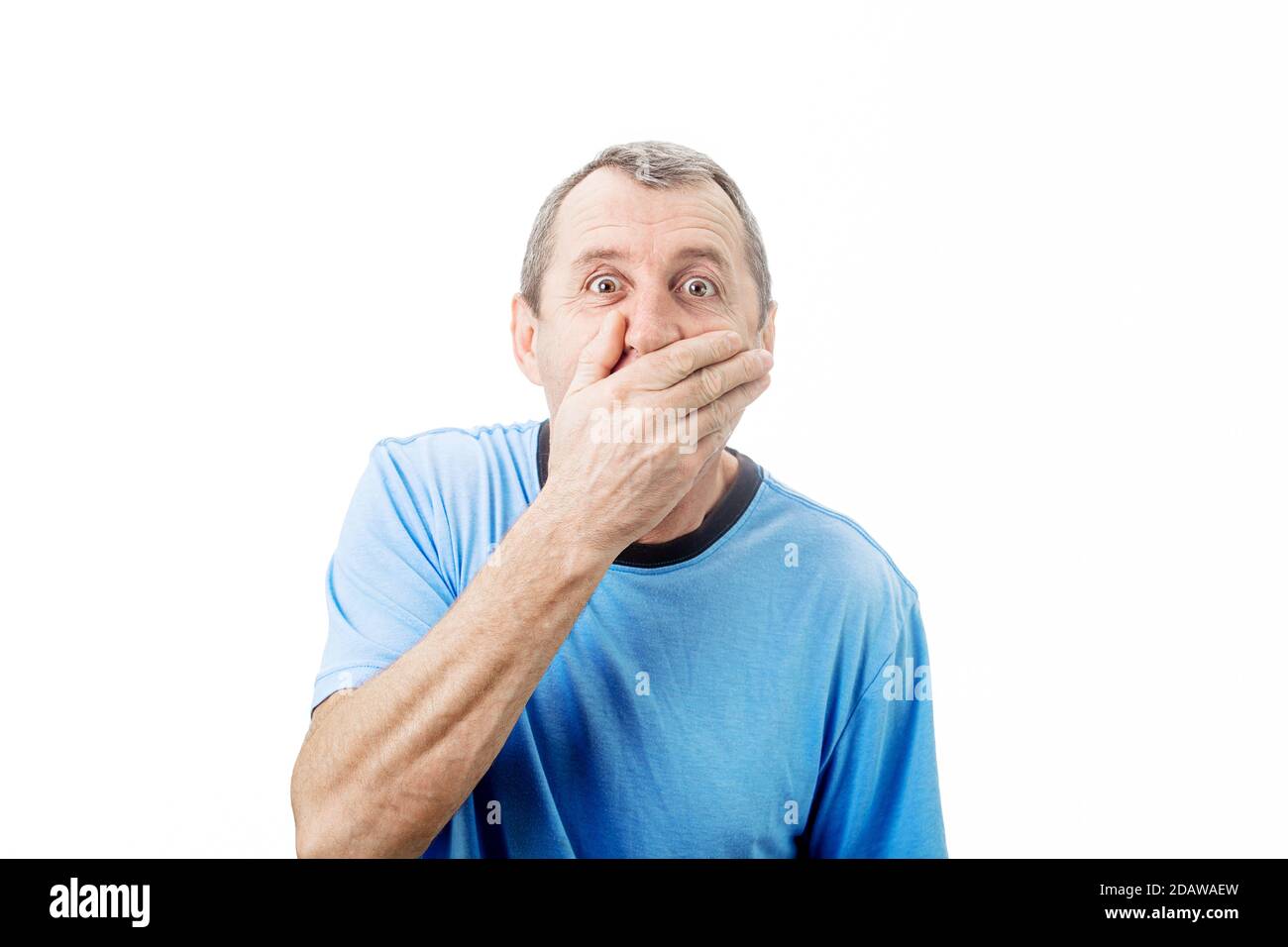 Schockierter Mann mittleren Alters mit weit geöffneten Augen bedeckt seinen Mund mit seiner Hand isoliert auf weißem Hintergrund mit Kopieplatz. Überraschte die Geschäftswelt Stockfoto