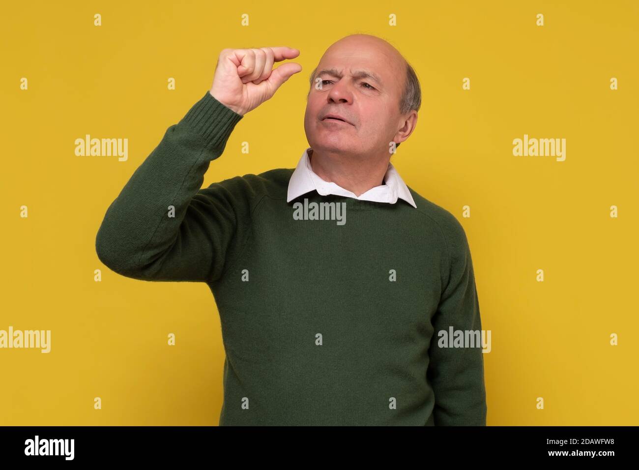 Enttäuschter älterer Mann, der nur eine kleine Länge zeigt Stockfoto