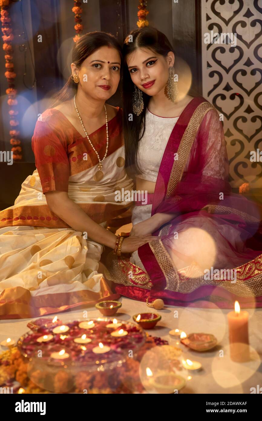 Eine indische Mutter und Tochter feiern das Festival of Lights, indem sie Kerzen und Diyas zu Hause anzünden, indische Familie feiert Diwali. Stockfoto