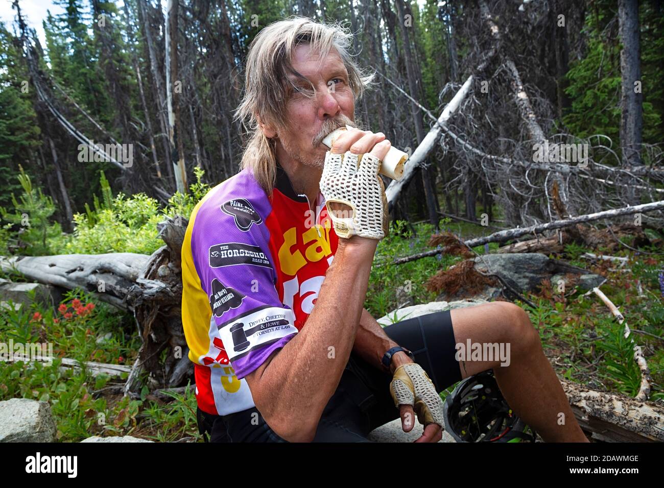 WA18101-00...WASHINGTON - Cyclist Genießen Sie eine schnelle, kalorienreiche Mahlzeit, bevor Sie die letzte Steigung zum Lone Frank Pass auf der Cascades Adventure Rou machen Stockfoto