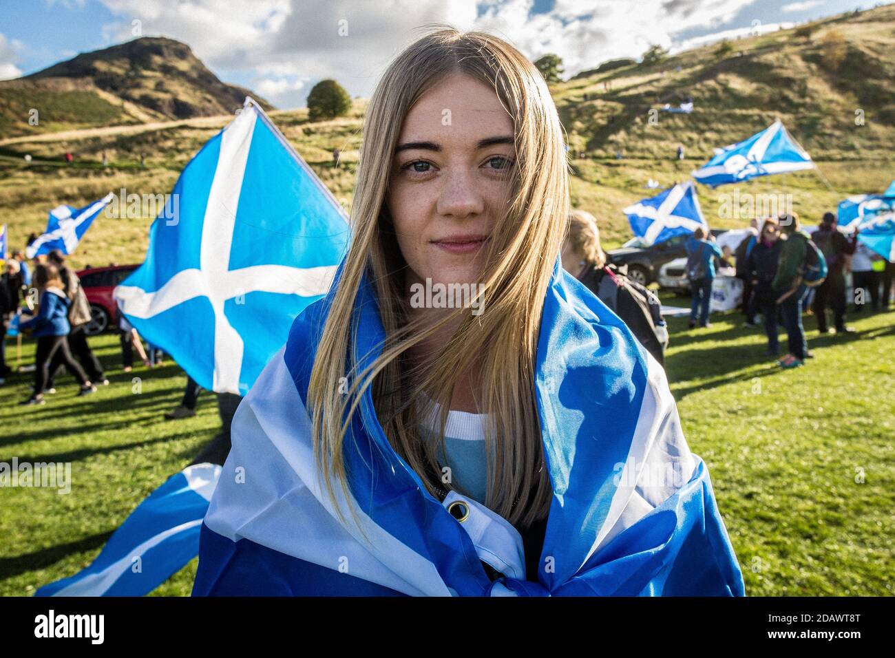 Junge Frau, die während des Pro Scottish Independence March am 6.10.2018 in Edinburgh, Großbritannien, in schottische Flagge gehüllt wurde. Stockfoto