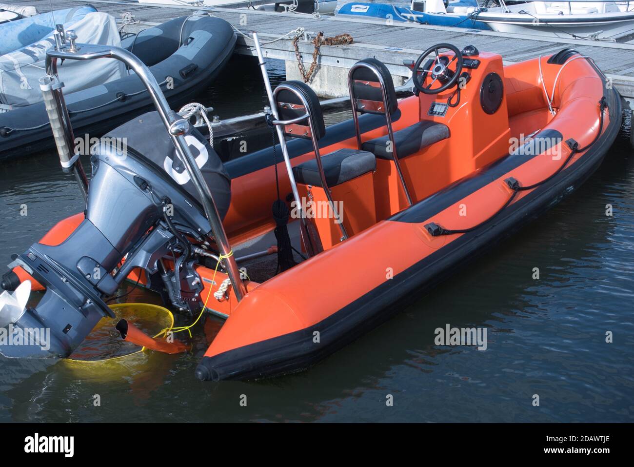 Ein orangefarbenes RIB - starres aufblasbares Boot, an das man gebunden ist Ein Ponton in einer Marina Stockfoto