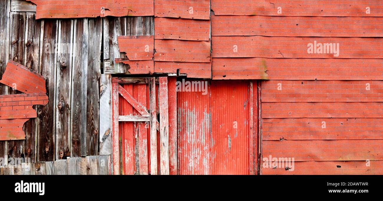 Eine sehr alte verlassene rot vernachlässigt verwittern leer verlassen historischen Bauernhof Scheune Gebäude Struktur Schuppen mit verschlechternden verblassten Seitenfassade Stockfoto