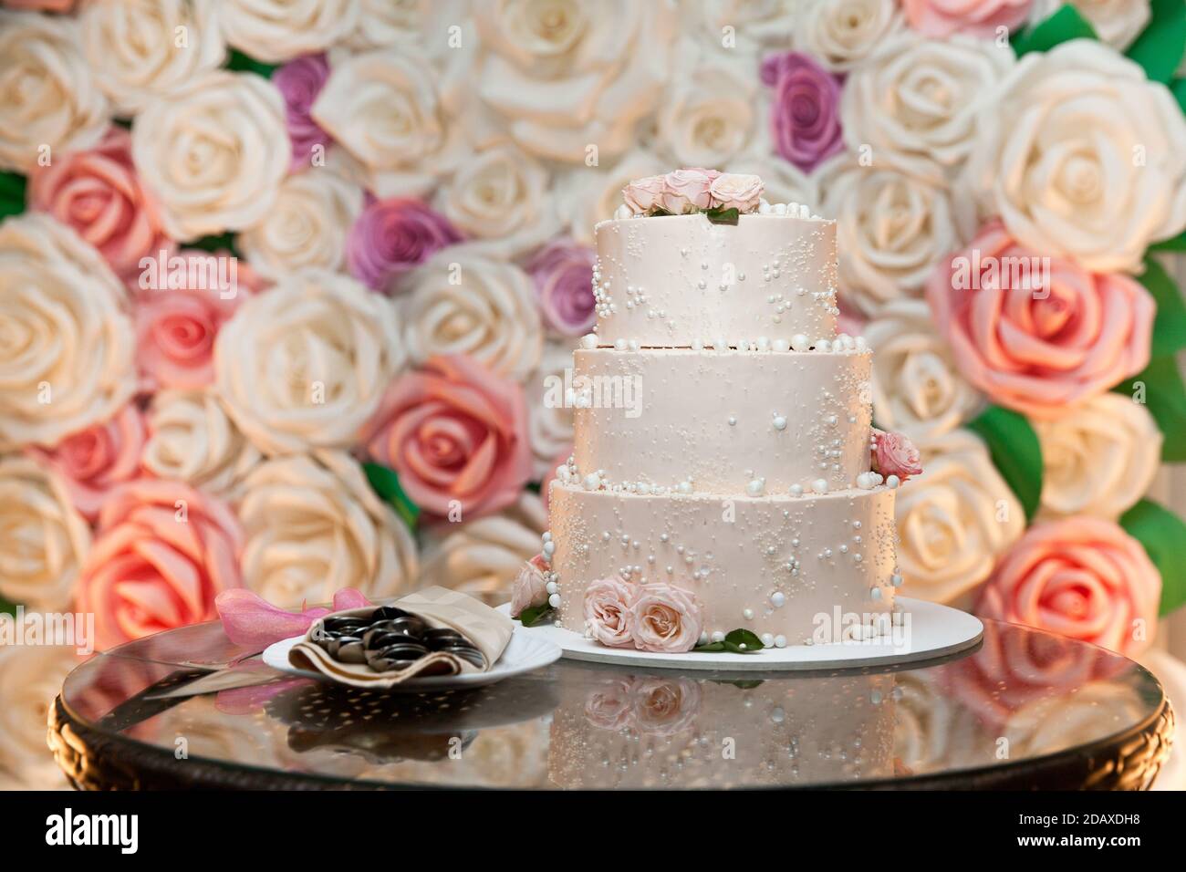 Der Hochzeitstorte. Weißer Kuchen mit Rosen verziert. Schönes Dessert für den Urlaub Stockfoto