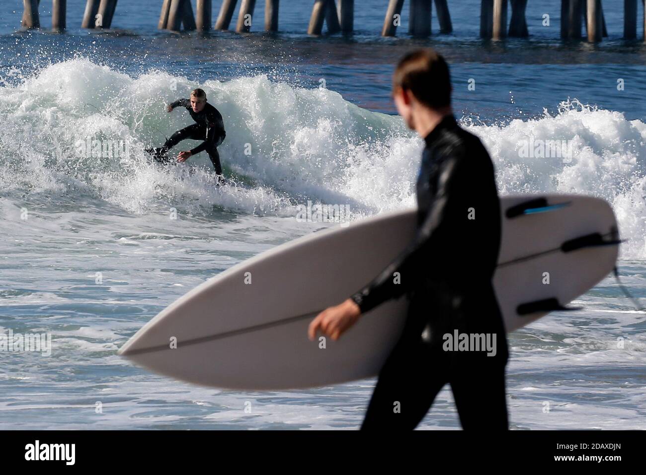 Los Angeles, Kalifornien, USA. November 2020. Ein Surfer reitet eine Welle in Huntington Beach, Kalifornien, Sonntag, 15. November 2020. Astronomische Hochtiden sind als "King Tides" bekannt und treffen die kalifornische Küste am Sonntag und Montagmorgen, und an einigen Orten bis Dienstag. Kredit: Ringo Chiu/ZUMA Wire/Alamy Live Nachrichten Stockfoto