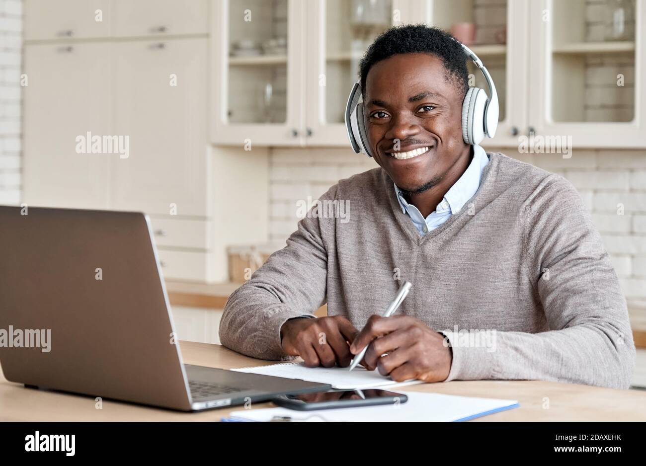 Afrikanischer Geschäftsmann Student trägt Kopfhörer elearning im Heimbüro. Stockfoto