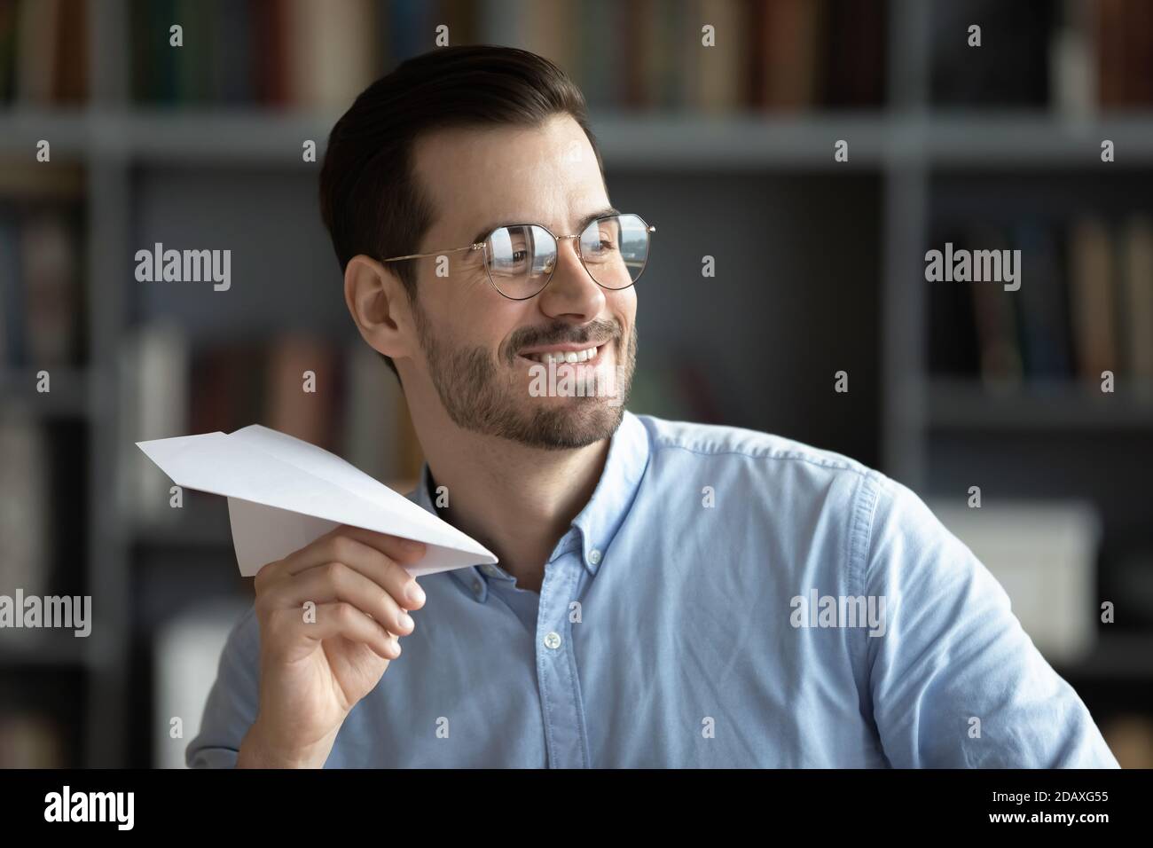 Optimistischer Geschäftsmann gefaltet Papier Flugzeug Spaß im Büro Stockfoto
