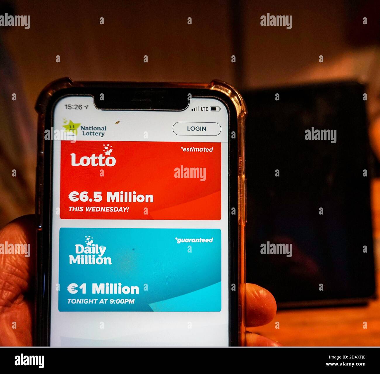 Irish National Lottery. Eine Handy-App für die Irish National Lottery in der Hand eines hoffnungsvollen Spielers gehalten. Stockfoto