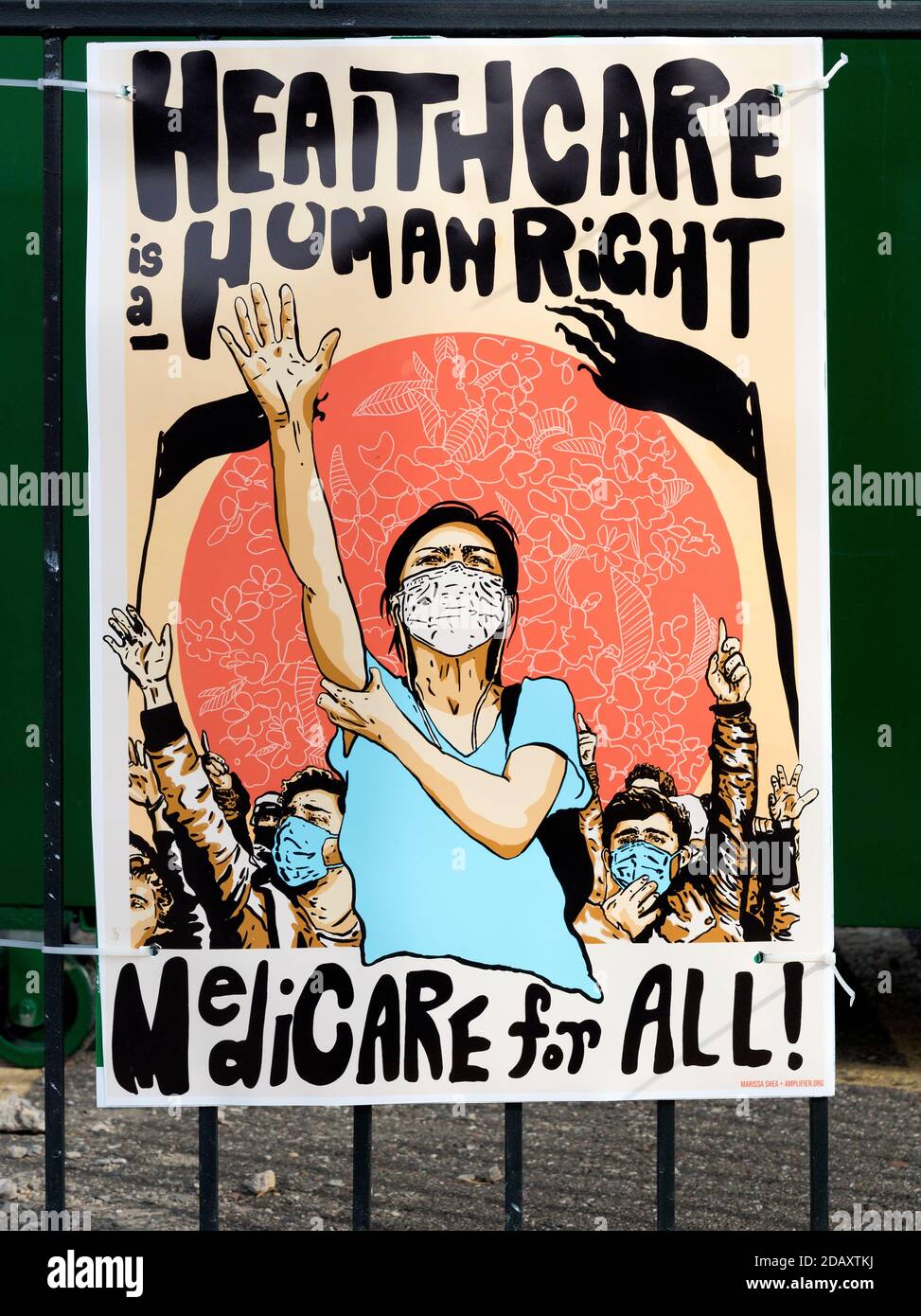 Ein bebildertes Poster, das Menschen mit Gesichtsmasken zeigt - Gesundheitswesen Ist ein Menschenrecht und Medicare für alle Slogans Stockfoto