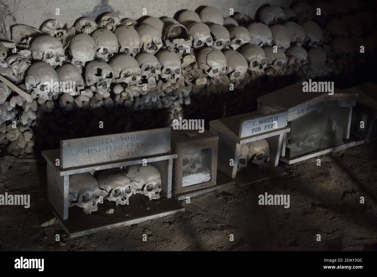 Auf dem Friedhof Fontanelle (Cimitero delle Fontanelle) in Neapel, Kampanien, Italien, werden menschliche Schädel geschachtelt und gestapelt. Das ehemalige Leichenhaus (Beinhaus) in einer Höhle im Stadtteil Materdei war der Ort, an dem sich in Neapel der spontane Kult der Hingabe an die Überreste namenlos Verstorbener entwickelte. Die Verteidiger des Kults besuchten die namenlosen Schädel im Beinhaus, um sie zu adoptieren und den Schädeln sogar Namen zu geben. Adoptierte Schädel wurden in der dekorierten Box platziert und wurden zum Gegenstand des regelmäßigen Gebets und Votivopfers. Stockfoto