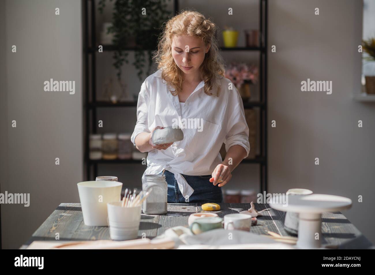 Produktionsprozess der Keramik. Anwendung der Glasurbürste auf Keramikgeschirr. Stockfoto
