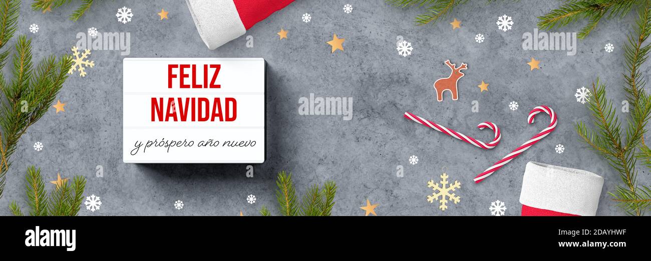 lightbox mit spanischer Botschaft für FROHE WEIHNACHTEN UND HAPPY NEW JAHR und weihnachtsdekoration auf Beton Hintergrund Stockfoto