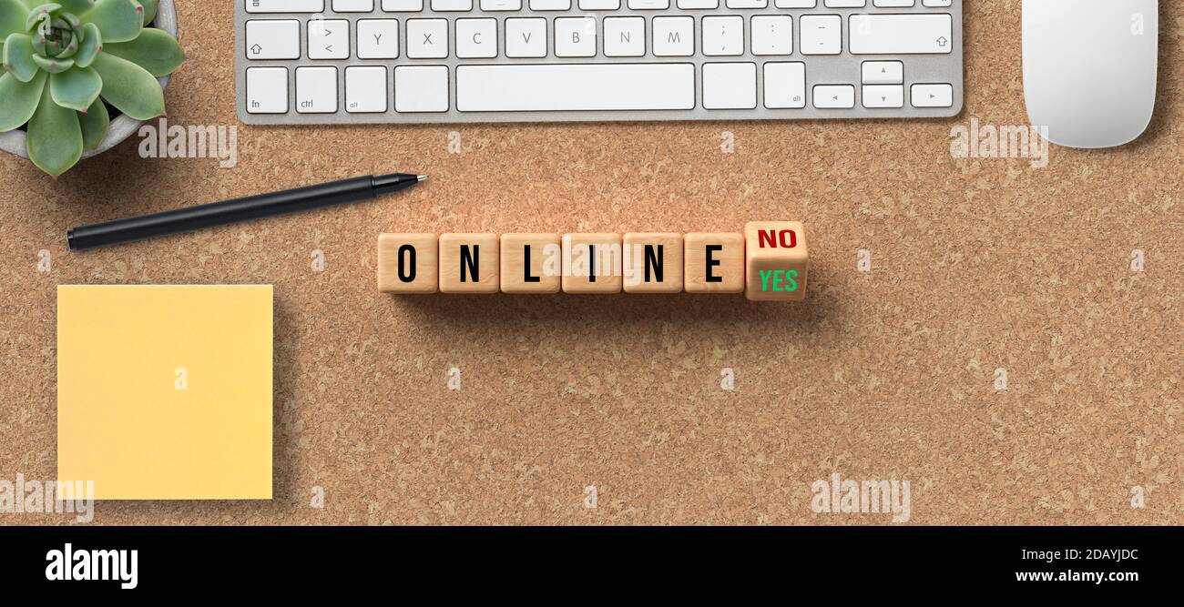Würfel mit Nachricht ONLINE JA / NEIN und Büroausstattung Auf Korkhintergrund Stockfoto