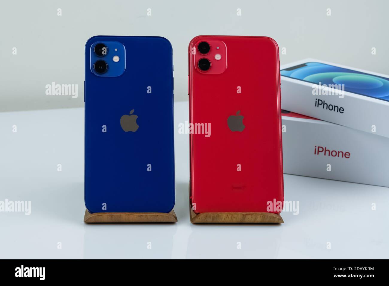 IPhone 12 in blau und iPhone 11 in rot nebeneinander. Stockfoto