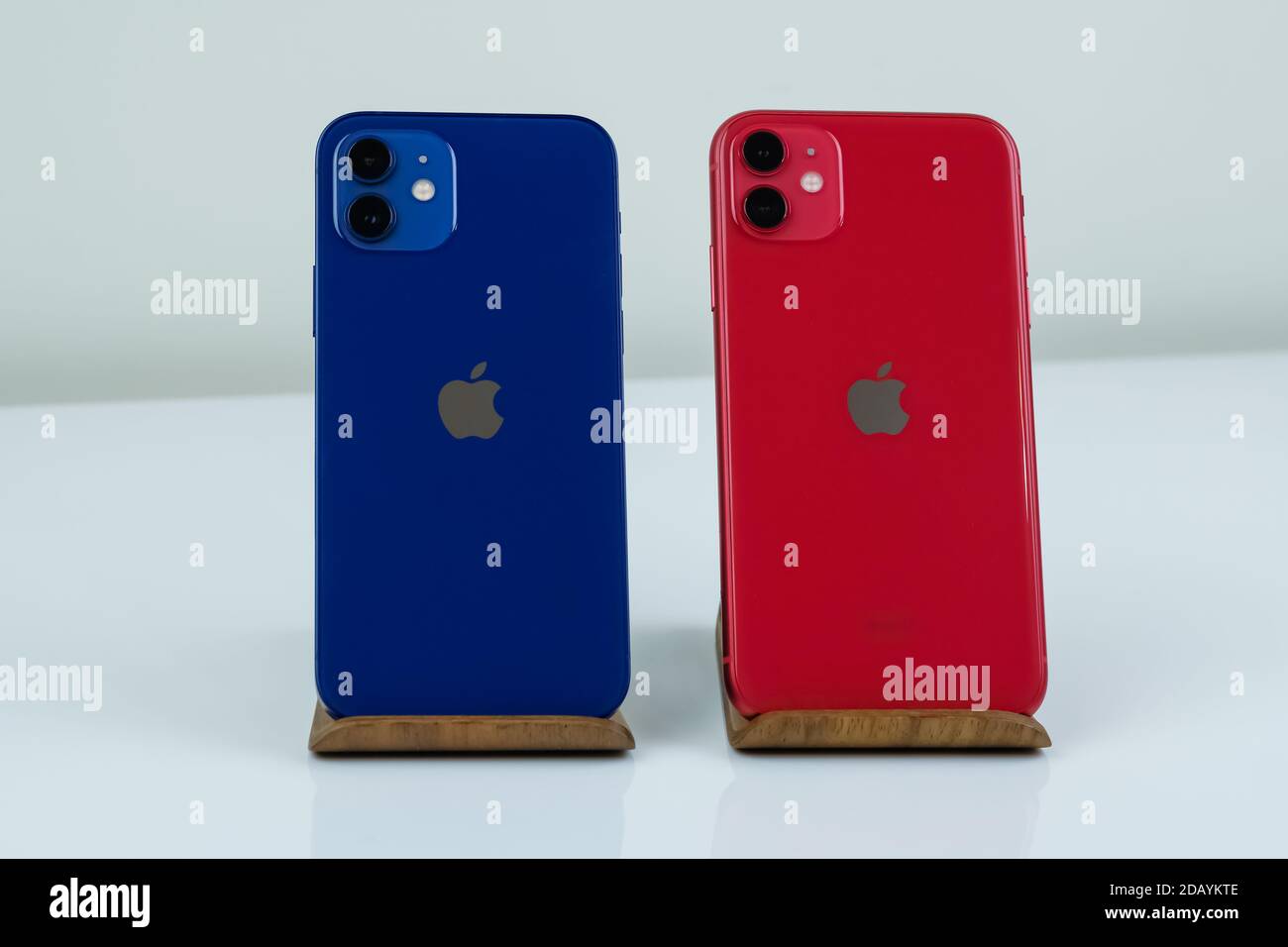 IPhone 12 in blau und iPhone 11 in rot nebeneinander. Stockfoto