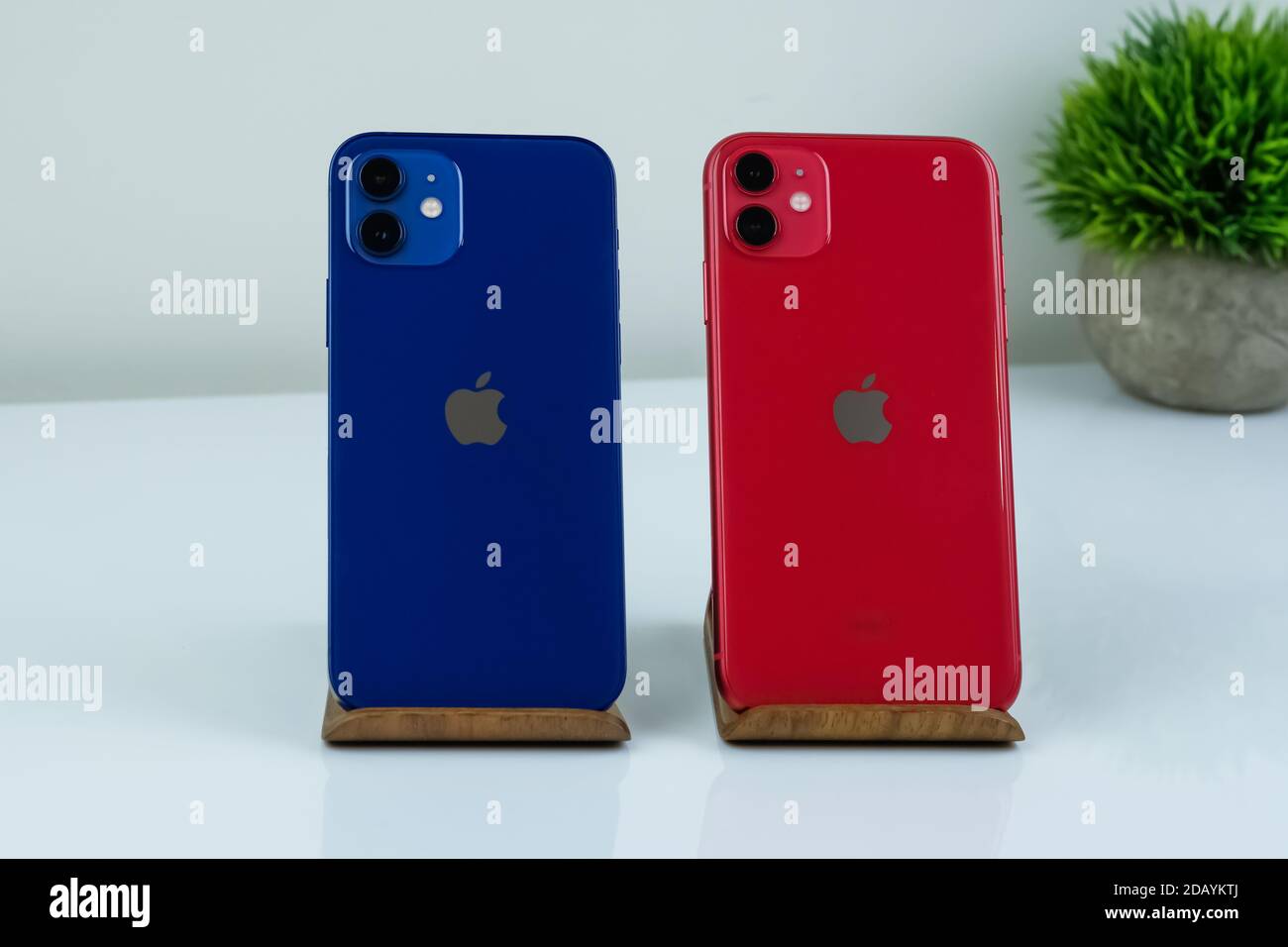 IPhone 12 in blau und iPhone 11 in rot nebeneinander. Stockfoto