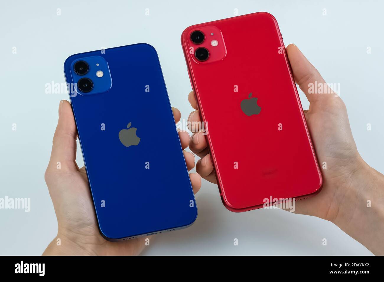 IPhone 12 in blau und iPhone 11 in rot nebeneinander. Stockfoto