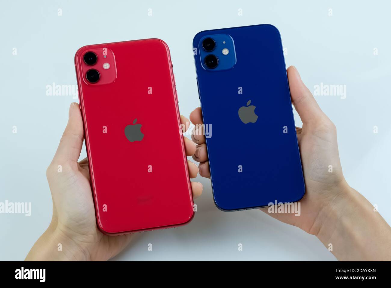 IPhone 12 in blau und iPhone 11 in rot nebeneinander. Stockfoto