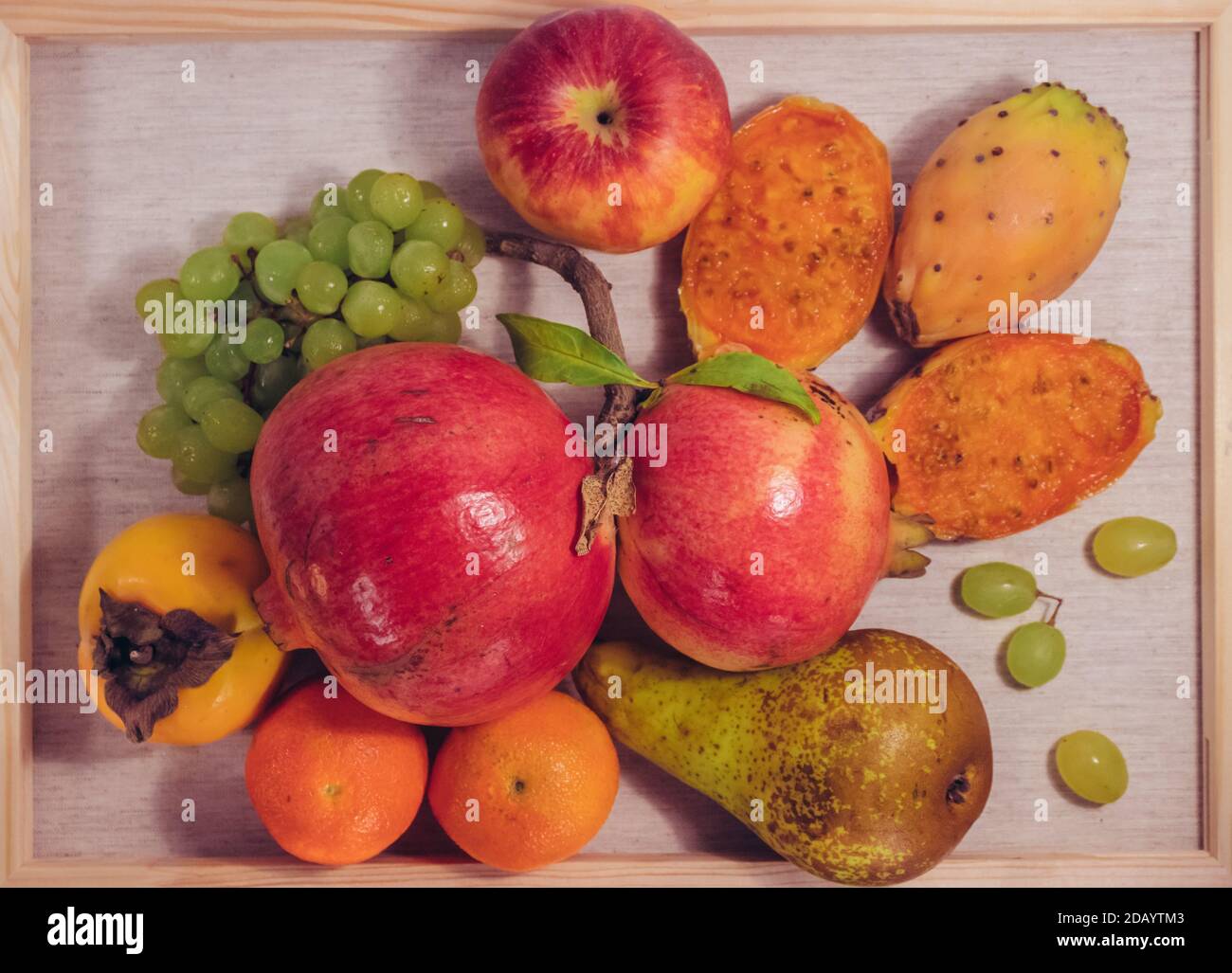 Stillleben Obst Foto auf Leinwand als Gemälde von Granatäpfeln, Kaktus Feigen, Kakimmon, Trauben, Mandarinen und Birne gemacht Stockfoto