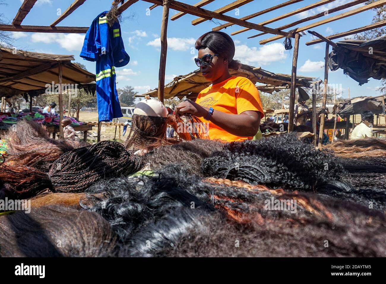 Faina Kambeta, seit über vier Jahren Friseur, gehört zu einer wachsenden Gruppe von Menschen in Harare, die gebrauchte Haarverlängerung umnutzen. Stockfoto