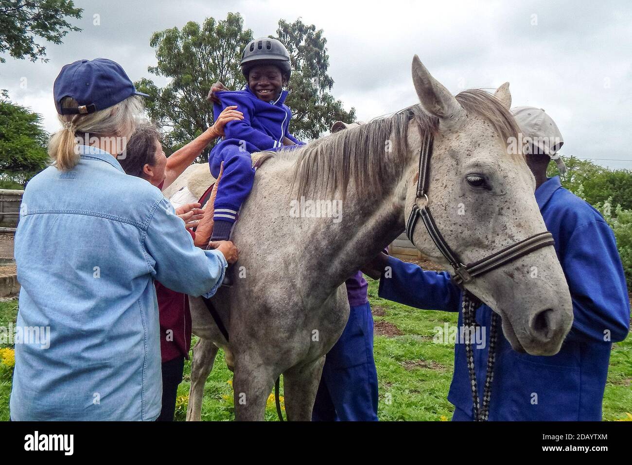 Emmanuel Choto, 8, Student an der King George VI, einer Schule für behinderte Kinder oder Kinder mit Autismus, reitet auf der Gumtree Farm in Willsgrove, Simbabwe, ein Pferd. Stockfoto