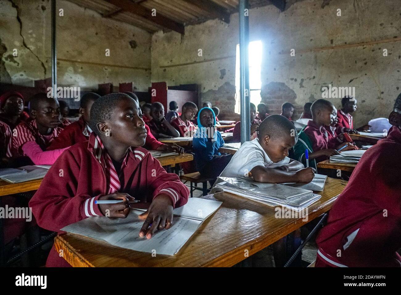 Die Schüler der sechsten Klasse, Ruvimbo Chambe (links), 12, und Blessing Tinarwo, 11, teilen sich einen Schreibtisch an ihrer Satellitenschule in Karoi, Simbabwe. Stockfoto