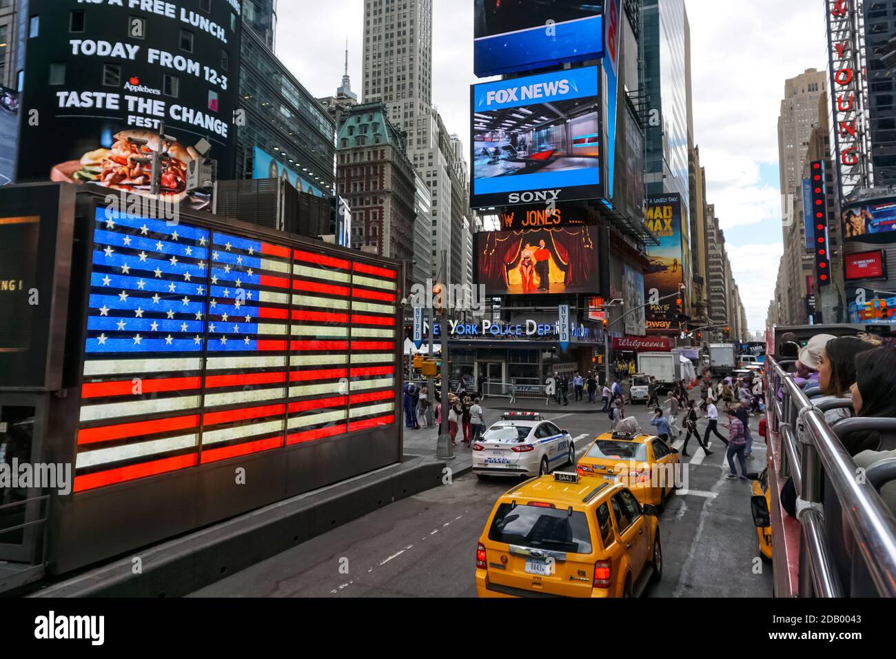 Times Square with yellow New York City Taxi cabs and tour buses driving through colorful billboards. Stockfoto