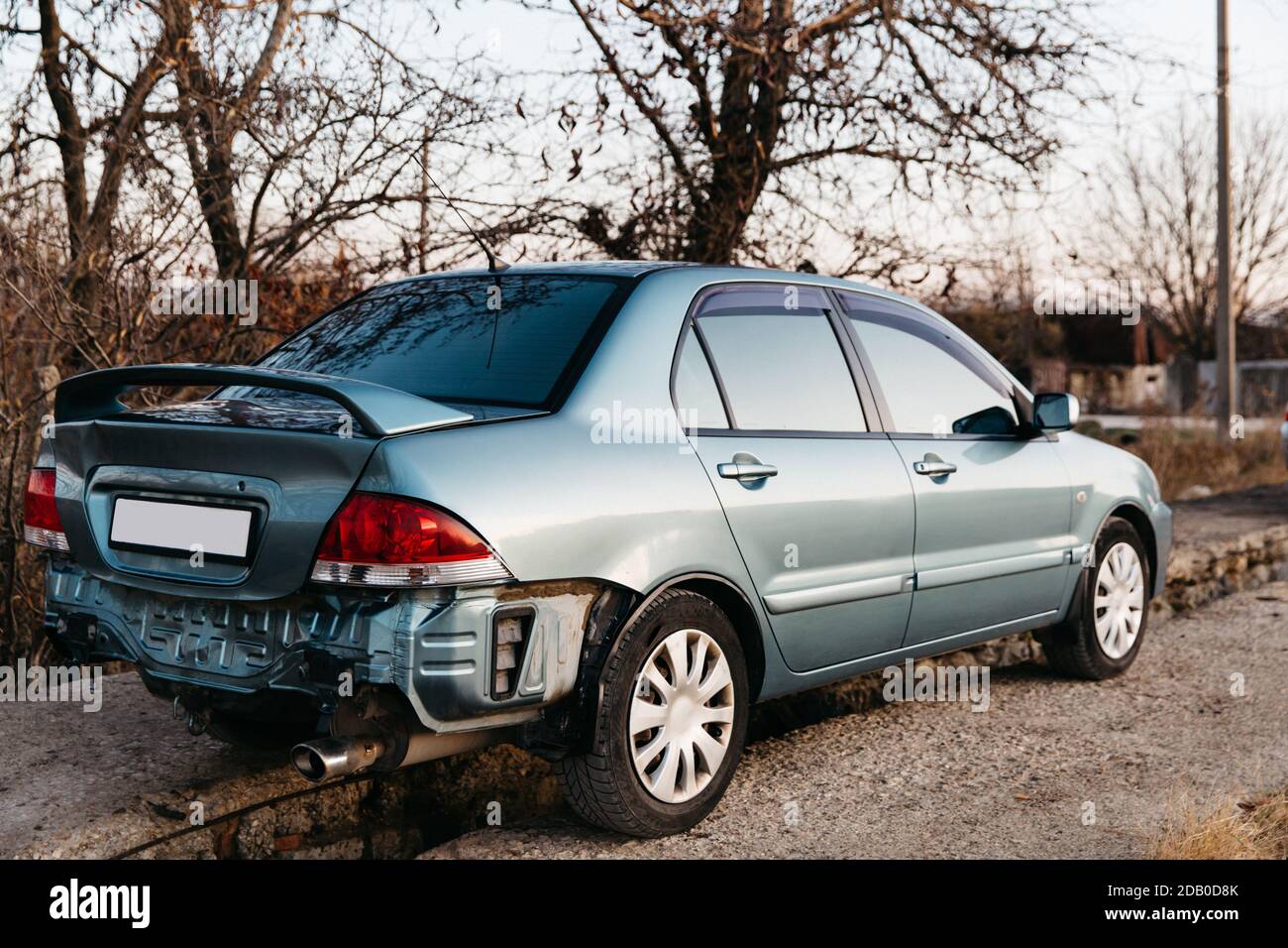 Ein Auto ohne Stoßstange, das Auspuffrohr ist sichtbar. Der Kofferraumdeckel ist verbeult. Auto nach Unfall. Eine Reparatur ist erforderlich. Kfz-Versicherungskonzept Stockfoto