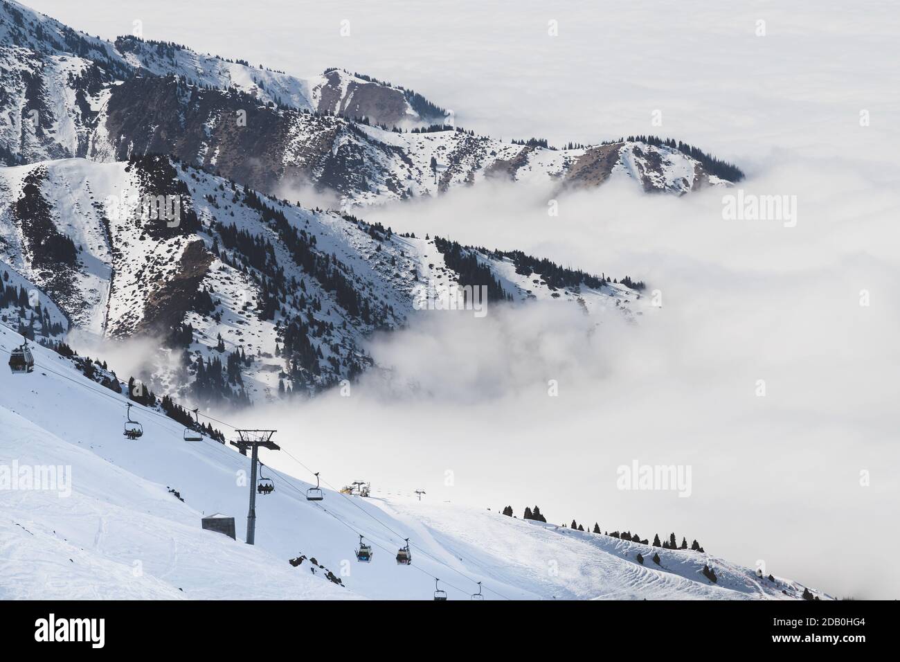Skigebiet in Bewölkt Tian Shan Berge im Nebel. Skilift auf der Piste. Stockfoto
