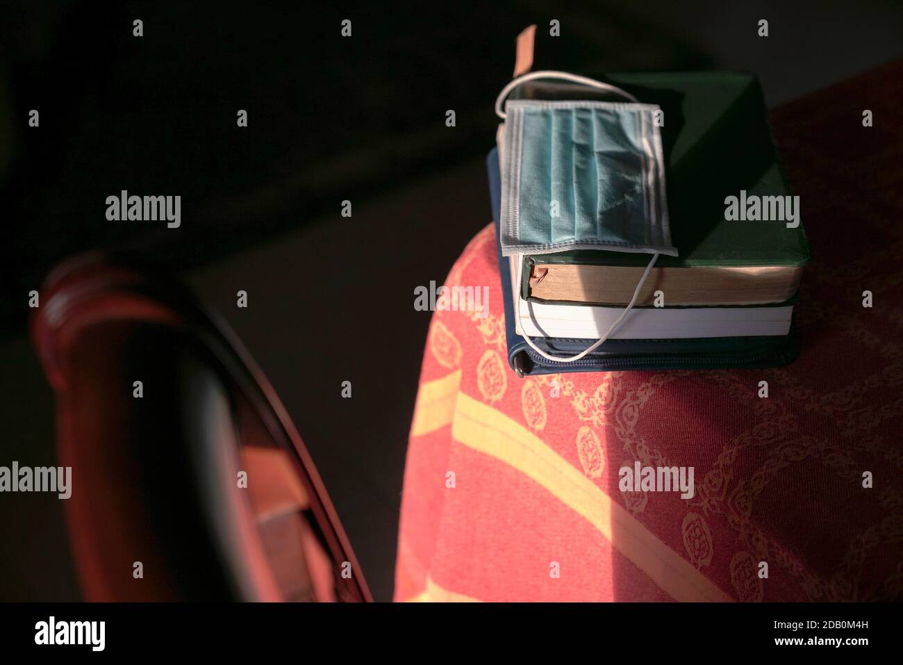 Gesichtsmaske auf gestapelten Büchern auf dem Tisch. Studie während des Pandemiekonzepts. Stockfoto