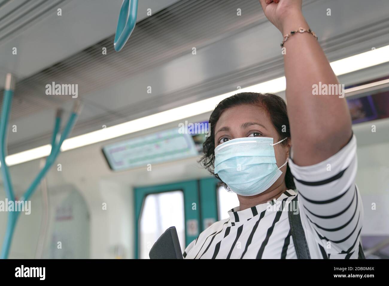 Frau Pendler trägt Gesichtsmaske innerhalb Zug. Pandemiekonzept für Geschäftsreisen. Stockfoto