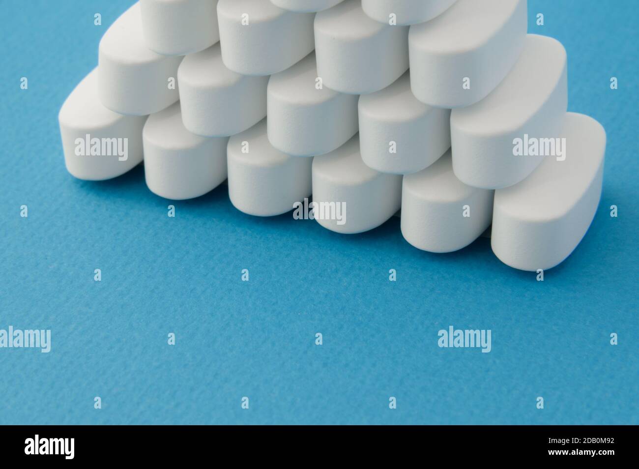 Apotheke Thema weiße Pillen Tabletten auf blauer Oberfläche mit Kopie Platz Stockfoto