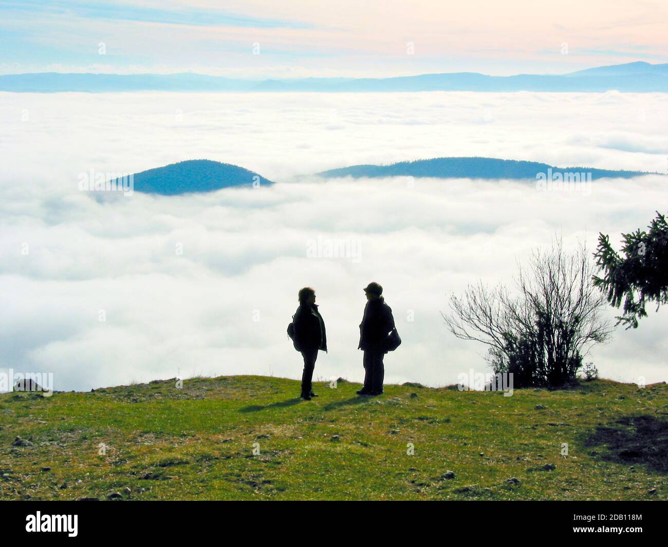 Silhouette von zwei Frauen vor Panoramablick auf die dichte Wolkendecke und den Himmel über dem Plateau 'hohe Wand', Niederösterreich Stockfoto
